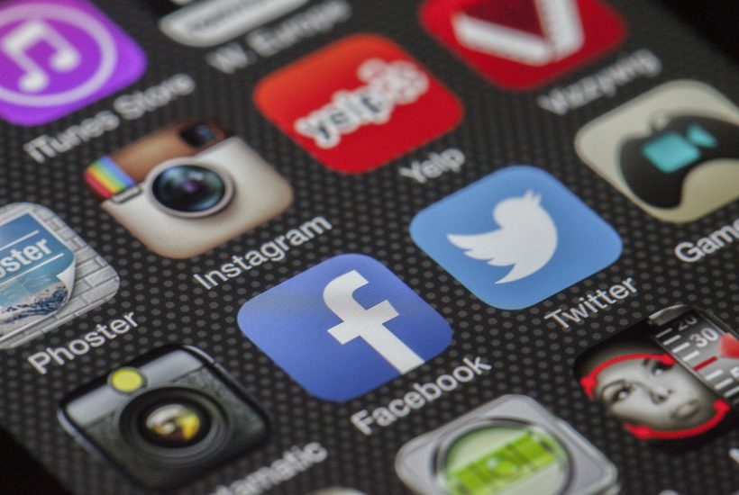 This picture show a smartphone with a bunch of social media icons.