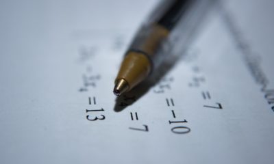 This picture show a pen and a paper with some data.